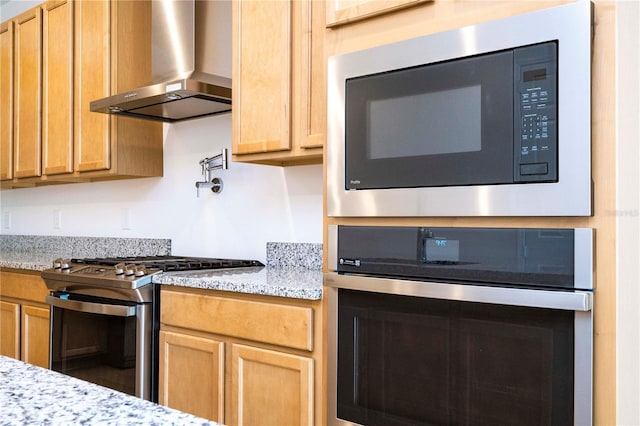 kitchen with oven, range, wall chimney range hood, light stone counters, and black microwave