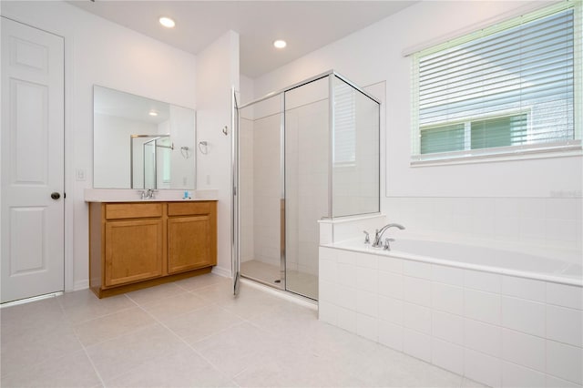 bathroom featuring plus walk in shower, vanity, and tile floors