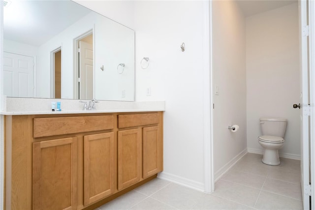 bathroom featuring tile flooring, vanity, and toilet