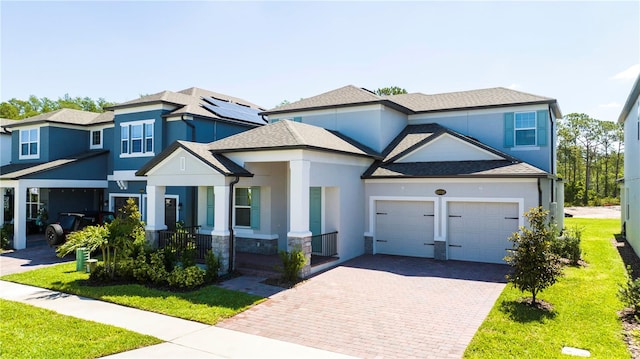 view of front of property with a garage, solar panels, and a front lawn