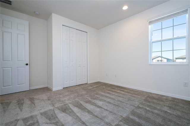 unfurnished bedroom featuring carpet and a closet