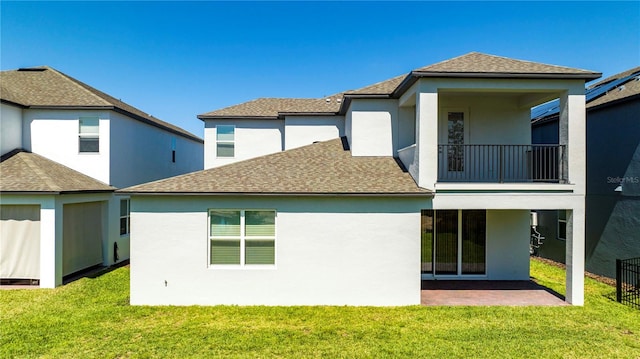 rear view of property with a balcony and a lawn