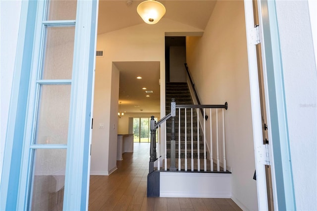 stairs featuring lofted ceiling and hardwood / wood-style floors