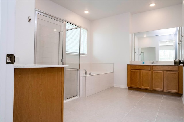 bathroom with plenty of natural light, separate shower and tub, tile flooring, and oversized vanity