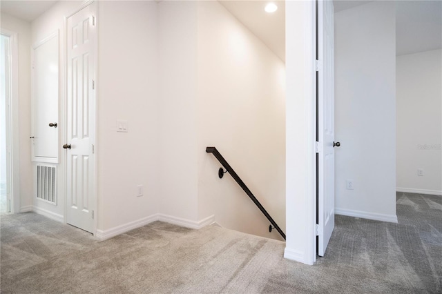 stairway featuring dark carpet