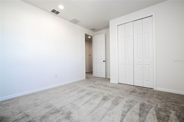 unfurnished bedroom featuring light colored carpet and a closet