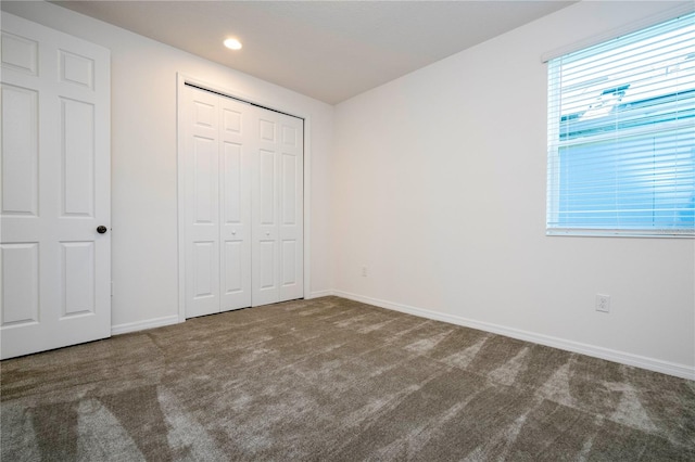 unfurnished bedroom featuring a closet and carpet flooring