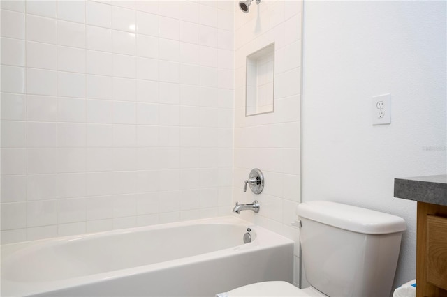 bathroom with tiled shower / bath combo and toilet