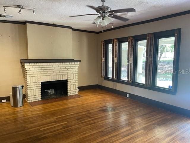 unfurnished living room featuring ceiling fan, hardwood / wood-style floors, crown molding, and a textured ceiling