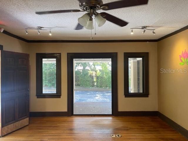 entryway featuring hardwood / wood-style floors, a textured ceiling, ceiling fan, and crown molding