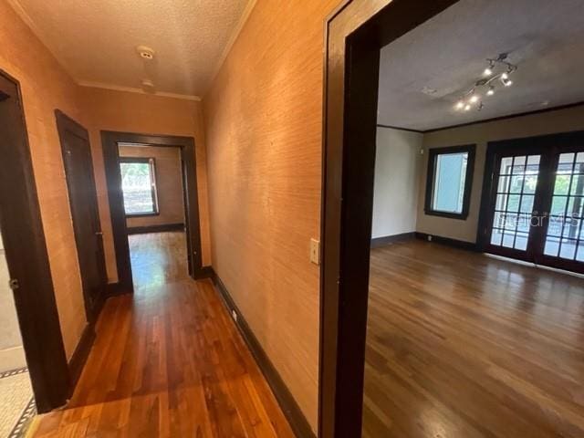 hall featuring french doors, dark hardwood / wood-style floors, and a textured ceiling