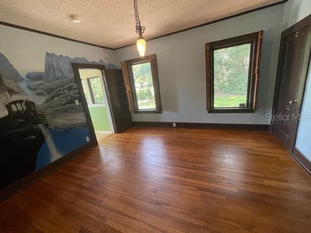 interior space featuring dark hardwood / wood-style floors, crown molding, and a textured ceiling