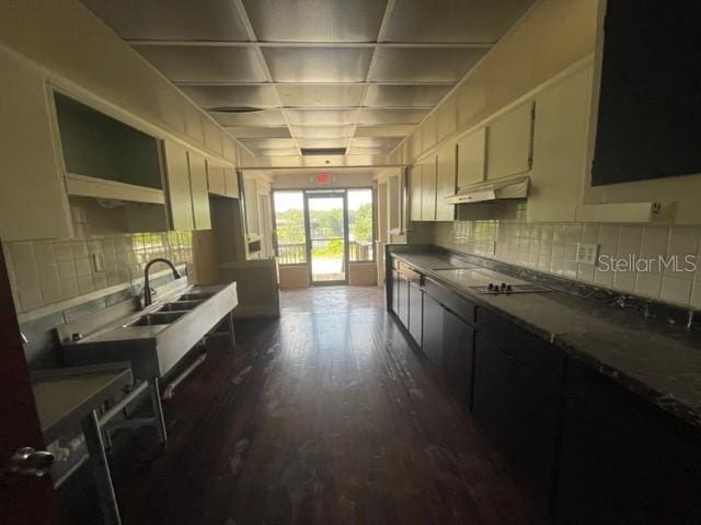 kitchen featuring cream cabinetry, cooktop, dark wood-type flooring, and sink