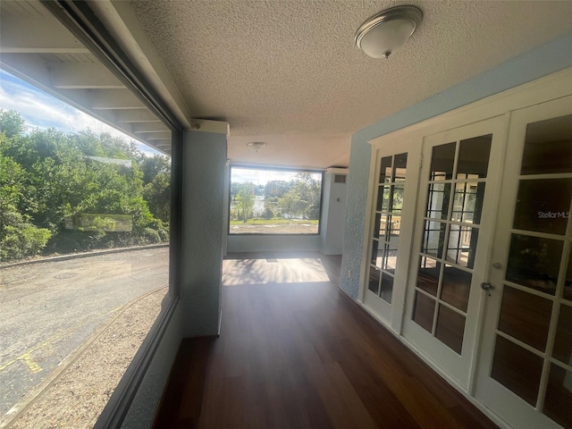 interior space with french doors, a textured ceiling, and dark hardwood / wood-style floors