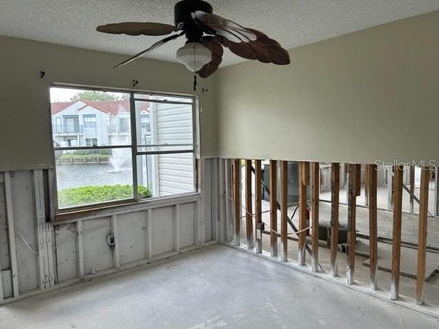 unfurnished room featuring a textured ceiling and ceiling fan