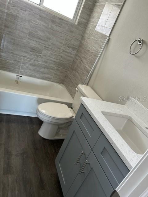 full bathroom with vanity, wood-type flooring, shower / bathing tub combination, and toilet