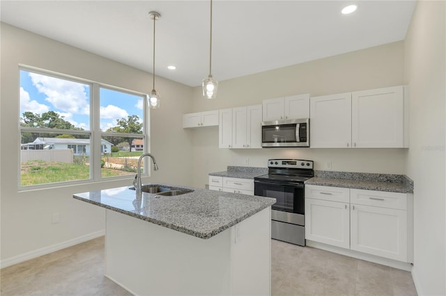 kitchen featuring decorative light fixtures, light stone countertops, white cabinetry, appliances with stainless steel finishes, and sink