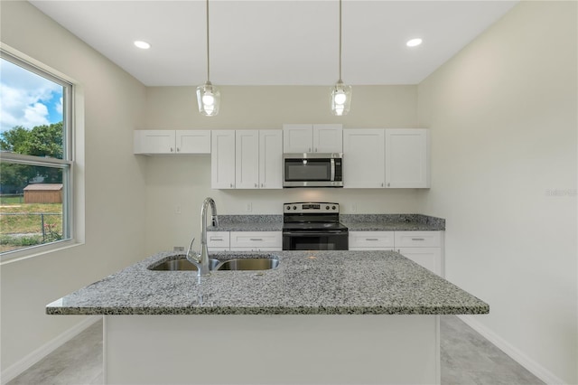 kitchen with hanging light fixtures, white cabinetry, a healthy amount of sunlight, appliances with stainless steel finishes, and light stone counters