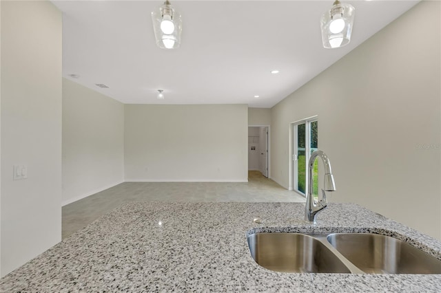 kitchen featuring light stone countertops and sink