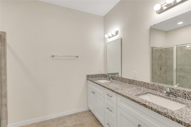 bathroom with tiled shower, tile floors, dual sinks, and vanity with extensive cabinet space