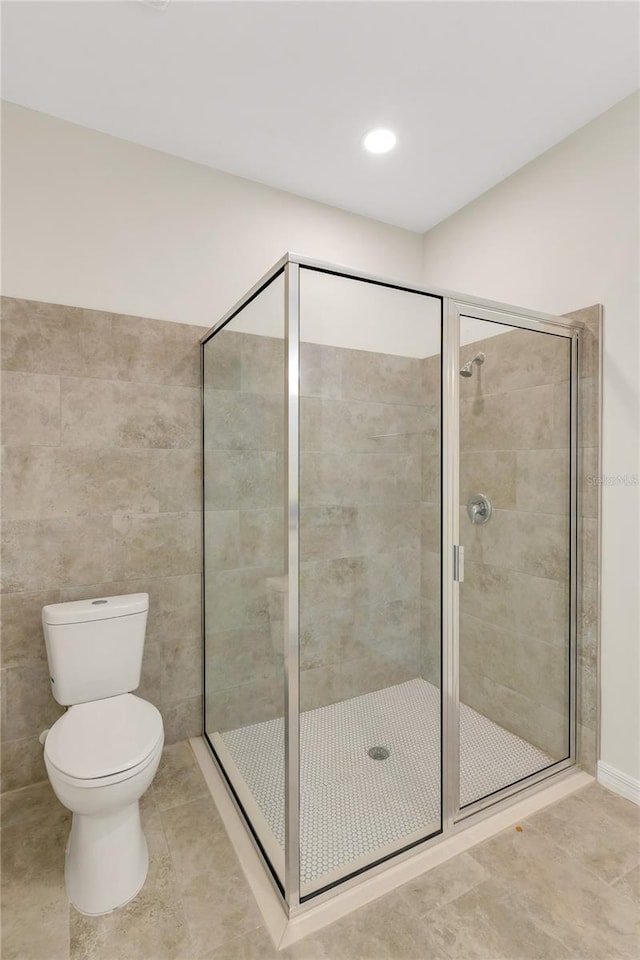 bathroom with an enclosed shower, toilet, and tile flooring