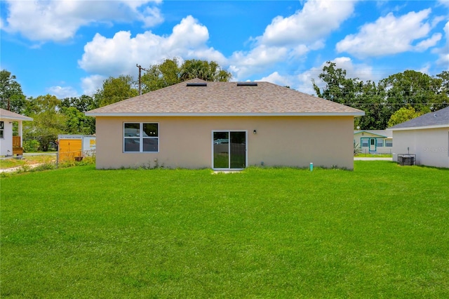 back of house featuring central AC unit and a yard