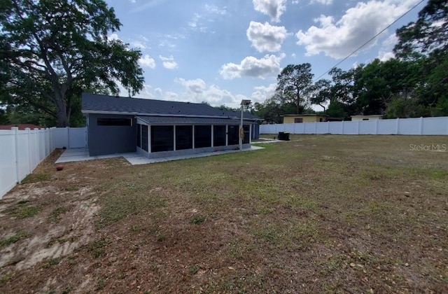 rear view of house featuring a lawn and a sunroom