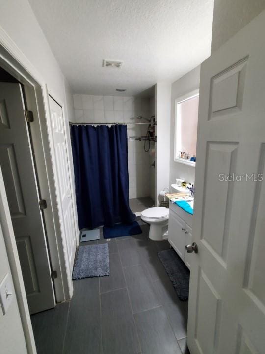 bathroom featuring toilet, tile floors, and vanity