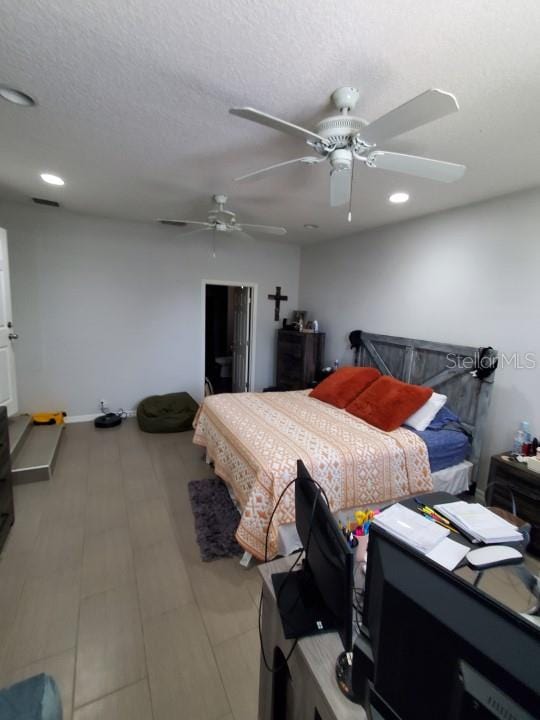 bedroom with ceiling fan and a textured ceiling