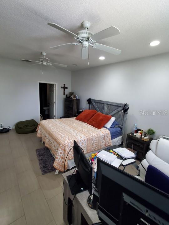 bedroom featuring a textured ceiling and ceiling fan