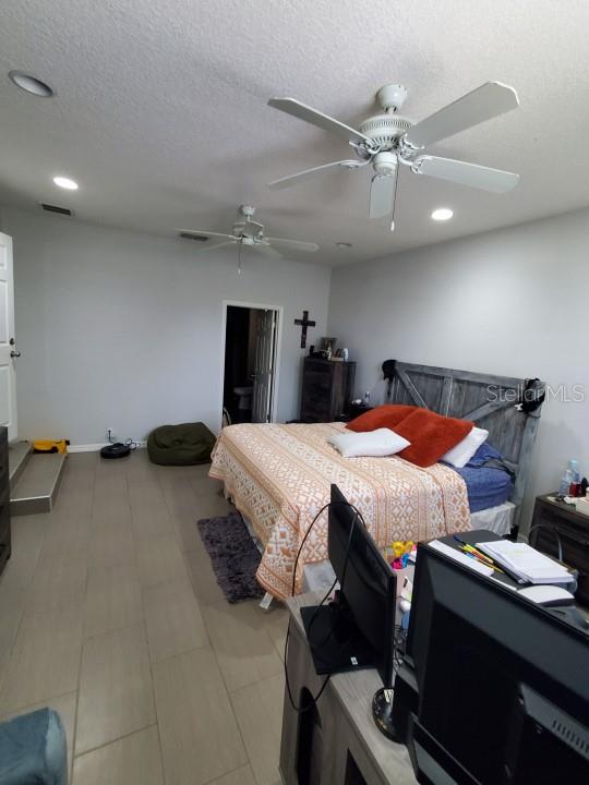 bedroom featuring a textured ceiling and ceiling fan