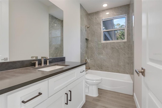 full bathroom featuring vanity, toilet, hardwood / wood-style flooring, and tiled shower / bath combo