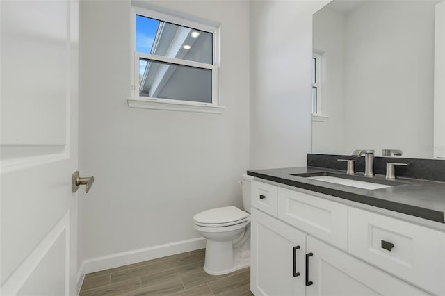 bathroom with vanity, toilet, and hardwood / wood-style floors