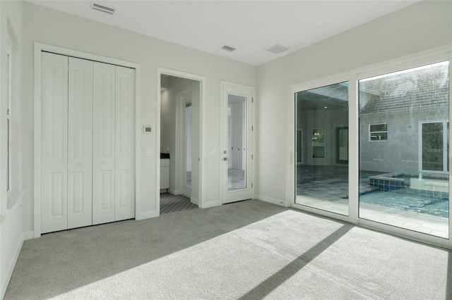 carpeted bedroom featuring a closet and access to exterior