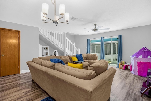 living room with dark hardwood / wood-style flooring and ceiling fan with notable chandelier