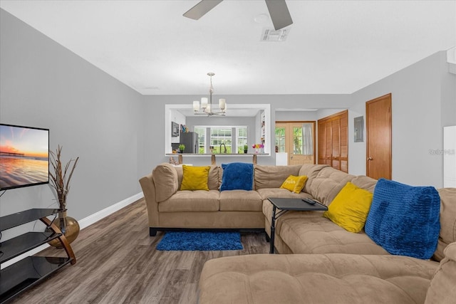 living room featuring dark hardwood / wood-style flooring and ceiling fan with notable chandelier