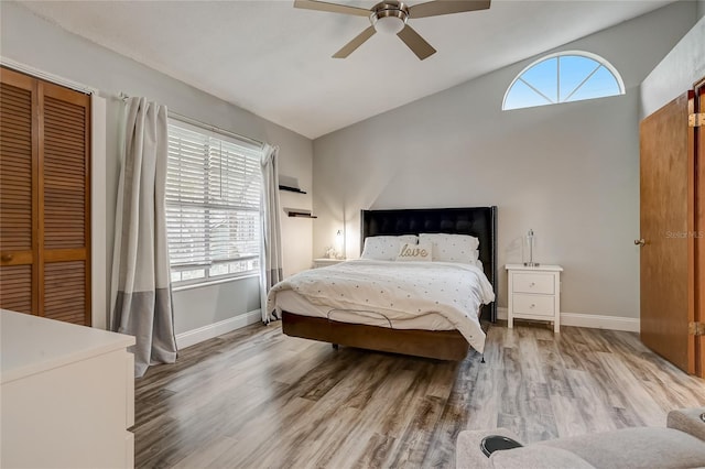 bedroom featuring lofted ceiling, a closet, ceiling fan, and light hardwood / wood-style flooring