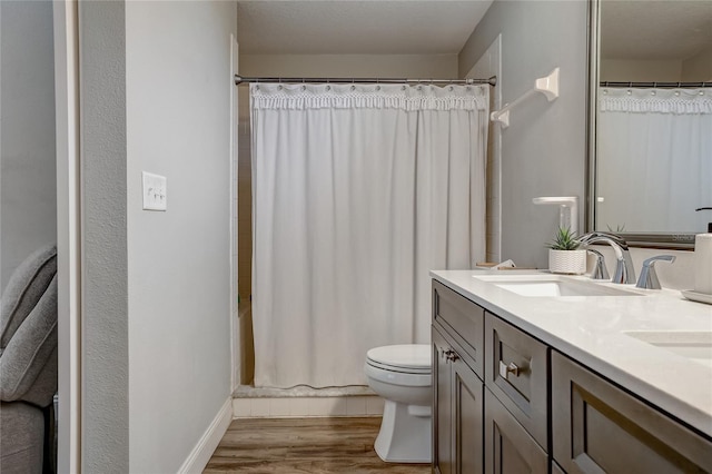 full bathroom featuring toilet, double vanity, shower / bathtub combination with curtain, and hardwood / wood-style floors