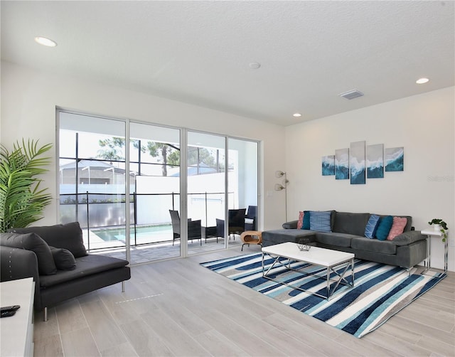 living room featuring a textured ceiling and light wood-type flooring