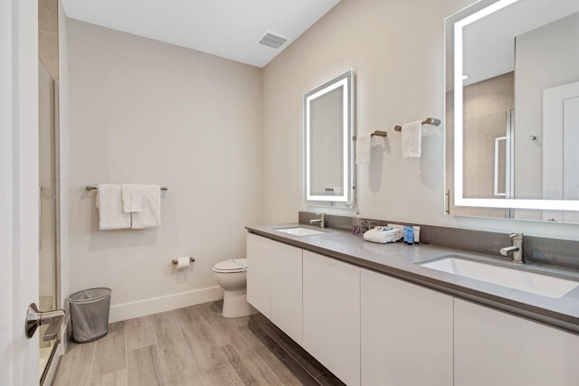 bathroom featuring an enclosed shower, double sink, wood-type flooring, toilet, and large vanity