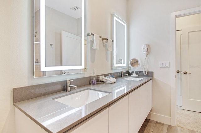 bathroom with double sink vanity and hardwood / wood-style flooring