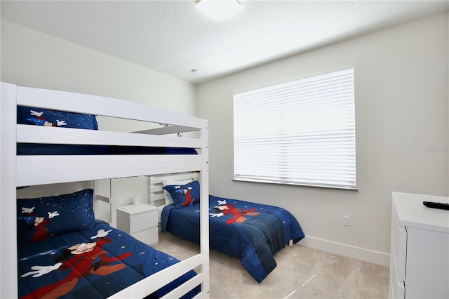 bedroom featuring a textured ceiling and light colored carpet