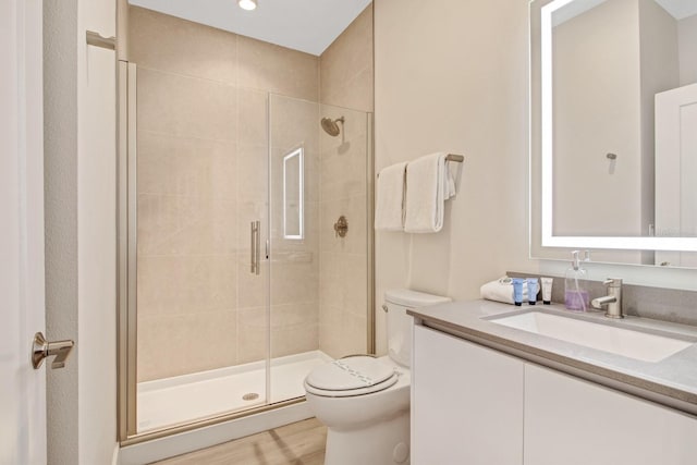 bathroom with walk in shower, toilet, and vanity