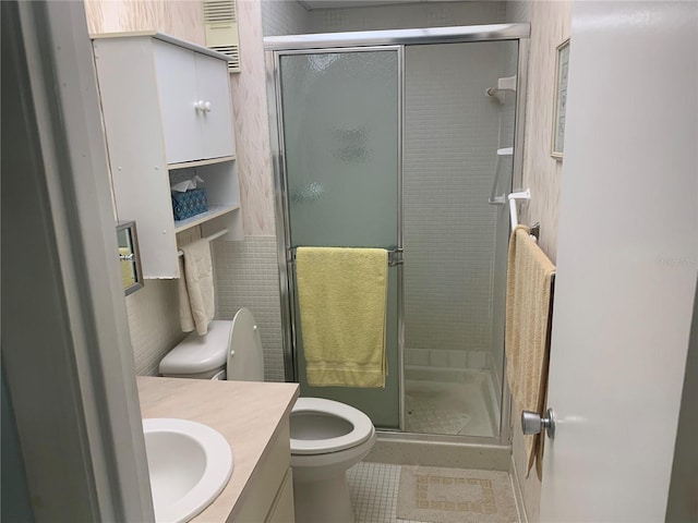 bathroom featuring toilet, vanity, a shower with door, and tile flooring