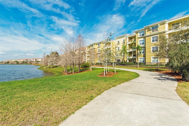 view of community with a yard and a water view