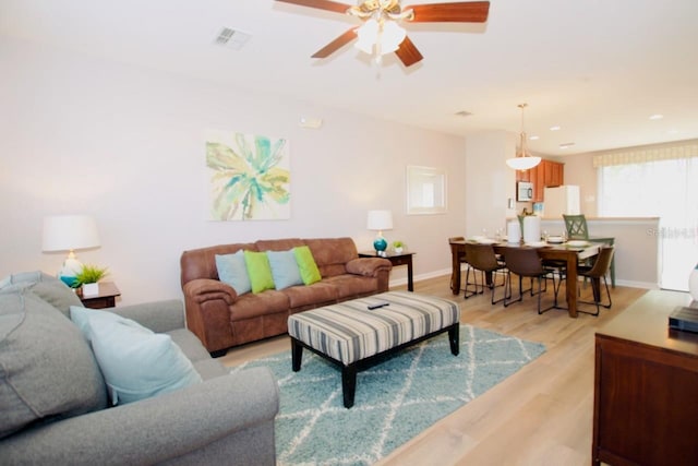 living room featuring ceiling fan and light hardwood / wood-style floors