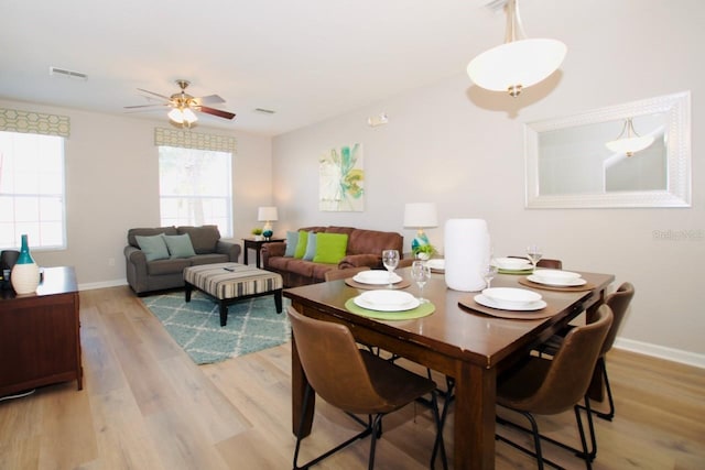 dining area with ceiling fan and light hardwood / wood-style flooring