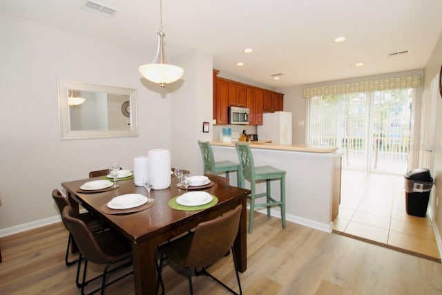 dining space with light hardwood / wood-style flooring