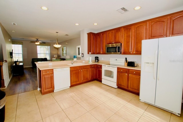 kitchen featuring pendant lighting, white appliances, sink, ceiling fan, and kitchen peninsula