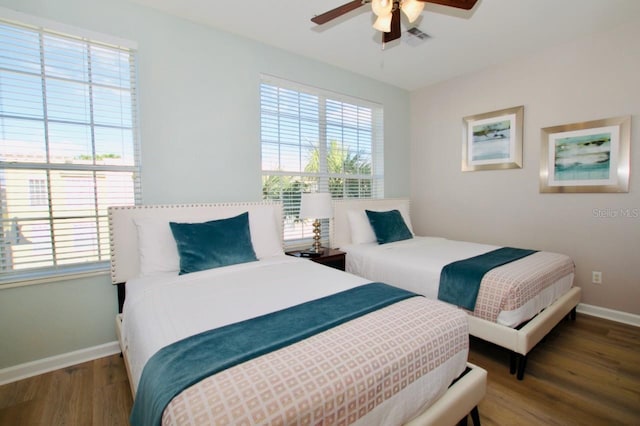 bedroom featuring ceiling fan, wood-type flooring, and multiple windows